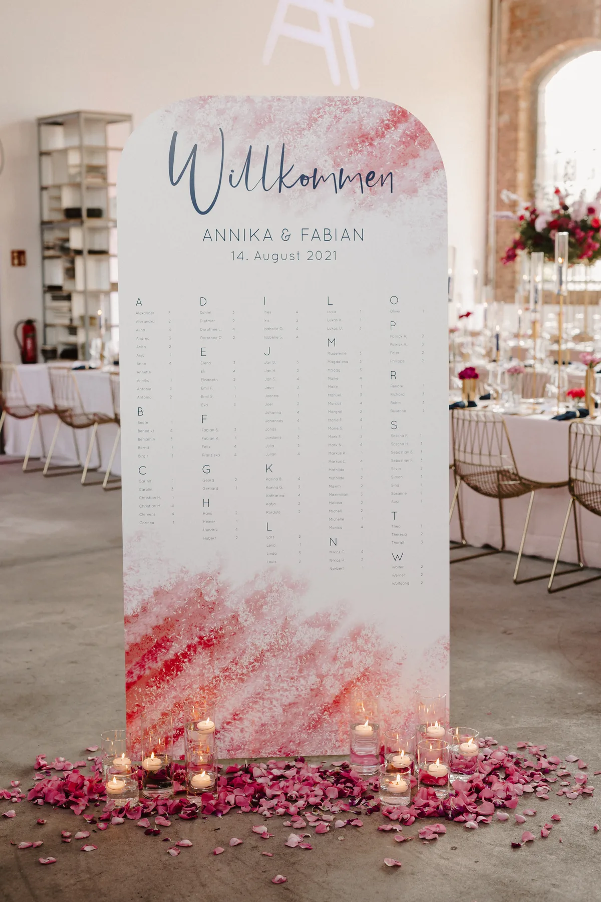 Großformatiger Sitzplan in Rosé mit Kalligrafie, Kerzen und Rosenblättern