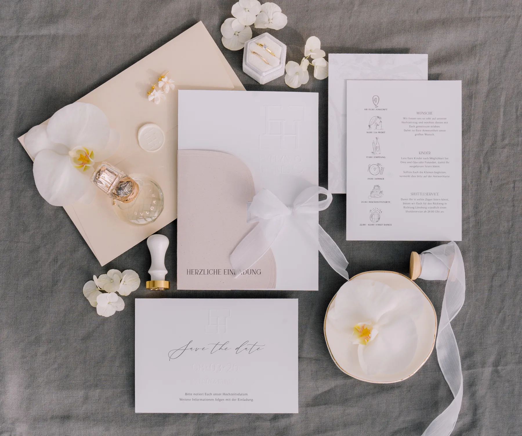 Hochzeitspapeterie in Weiß mit Blindprägung, Bogenform und Chiffonband