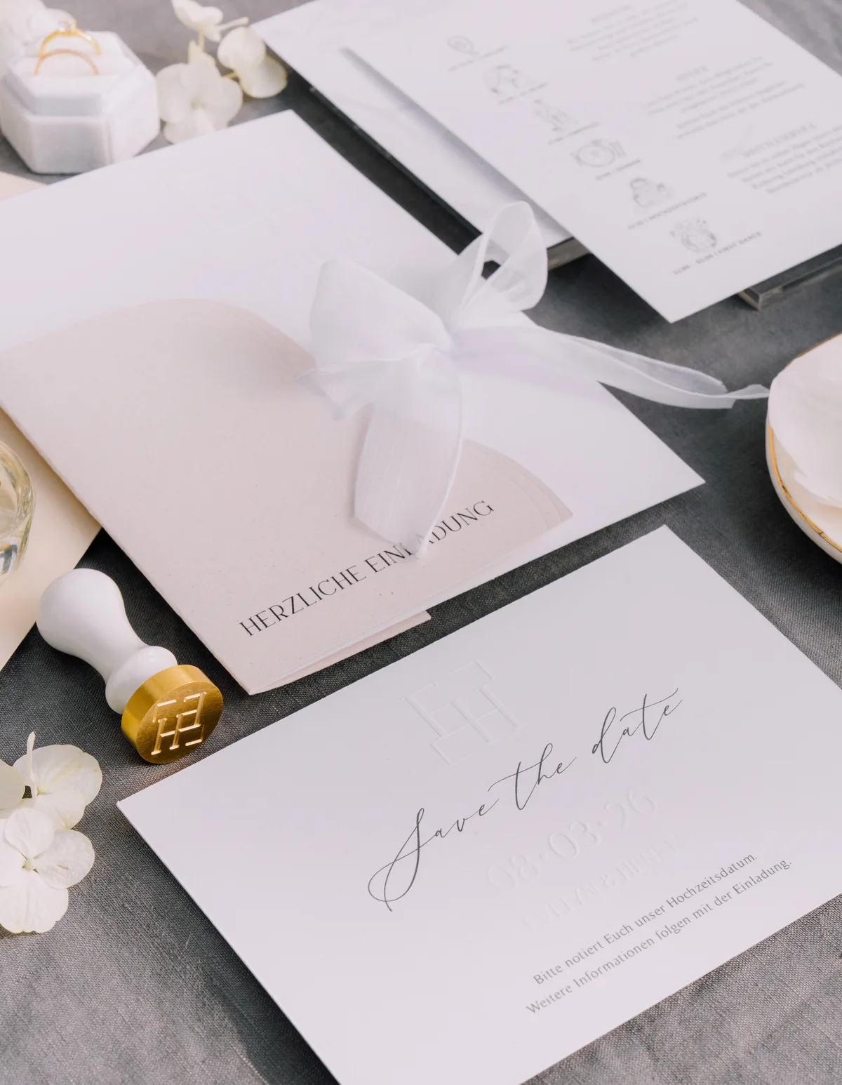 Save the Date mit geprägtem Monogramm und Goldstempel auf Leinen
