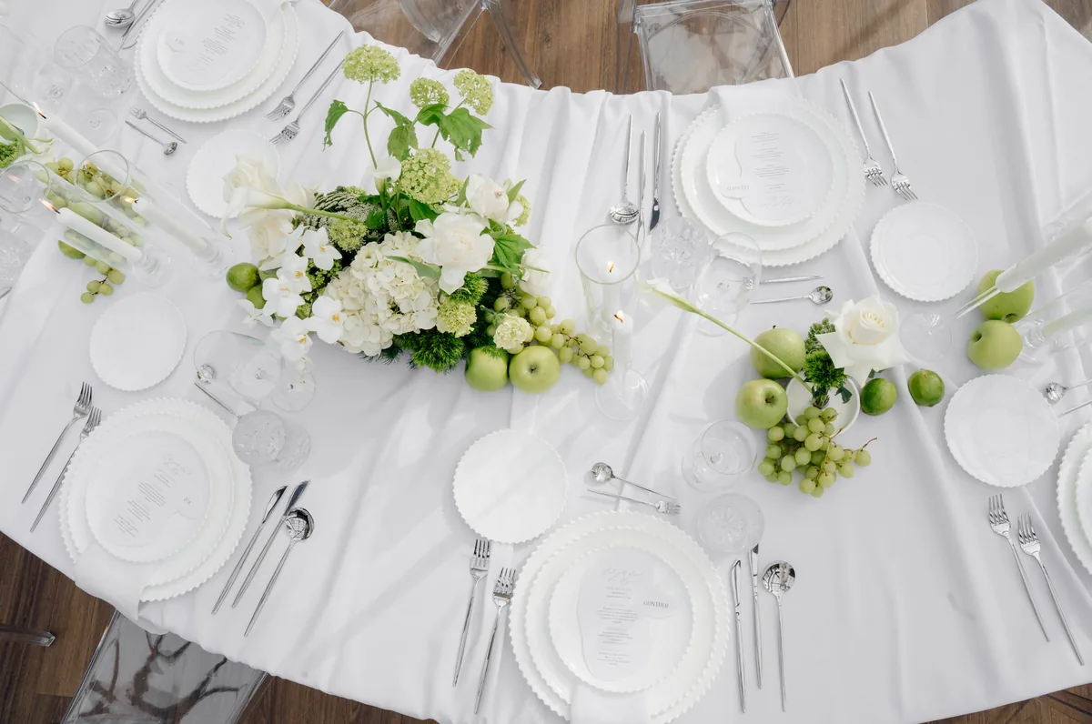 Runde Hochzeitstafel von oben mit weißer Floristik, Limetten und Menükarten