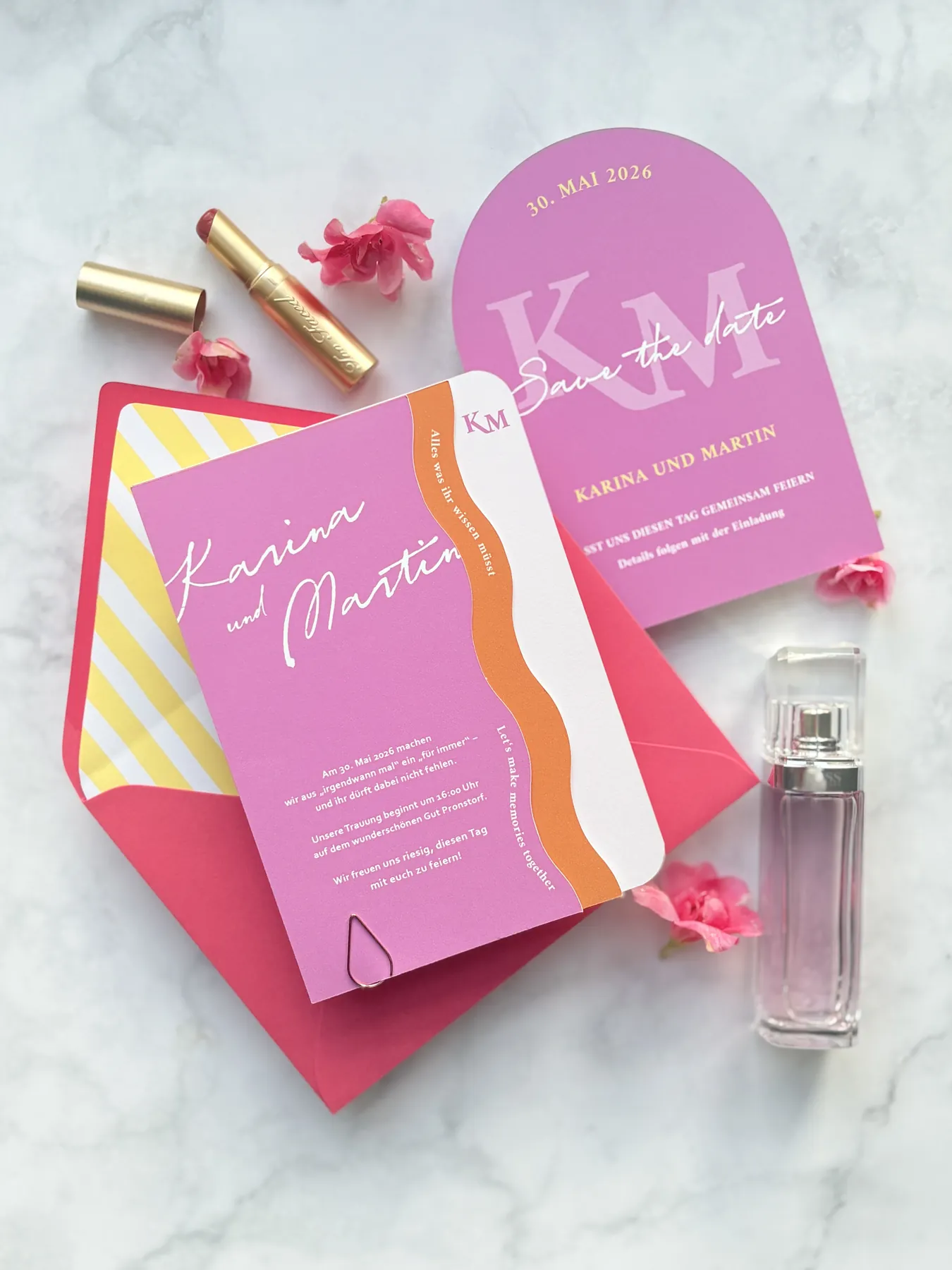 Pinke Save the Date in Bogenform und Einladung mit orangefarbener Welle