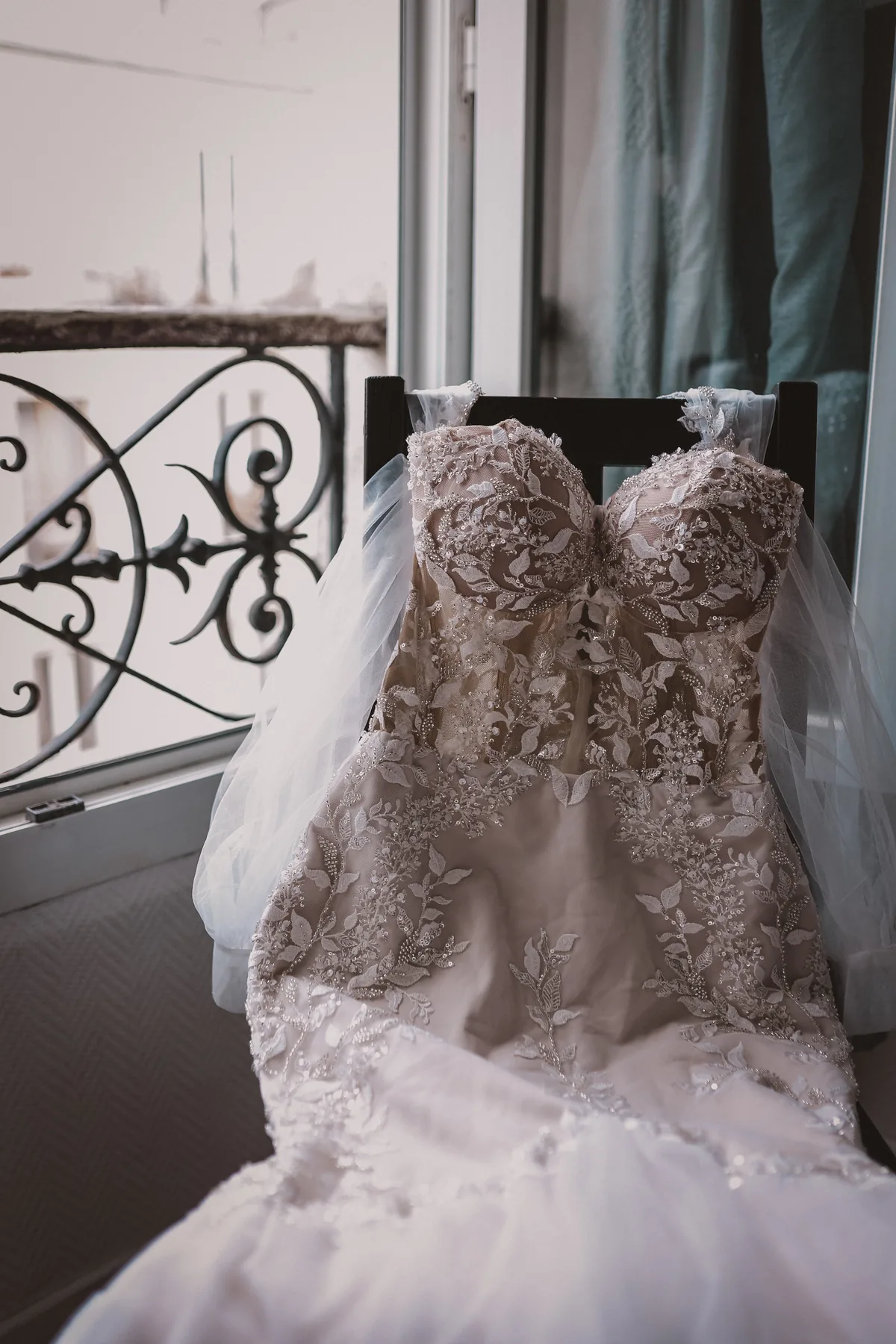 Brautkleid mit Spitze und Perlenstickerei am Fenster eines Pariser Apartments