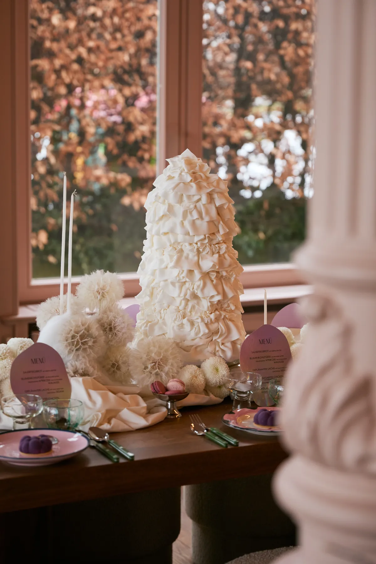 Hochzeitstafel in Rosa mit Menükarten und einer Torte aus Zuckerblüten